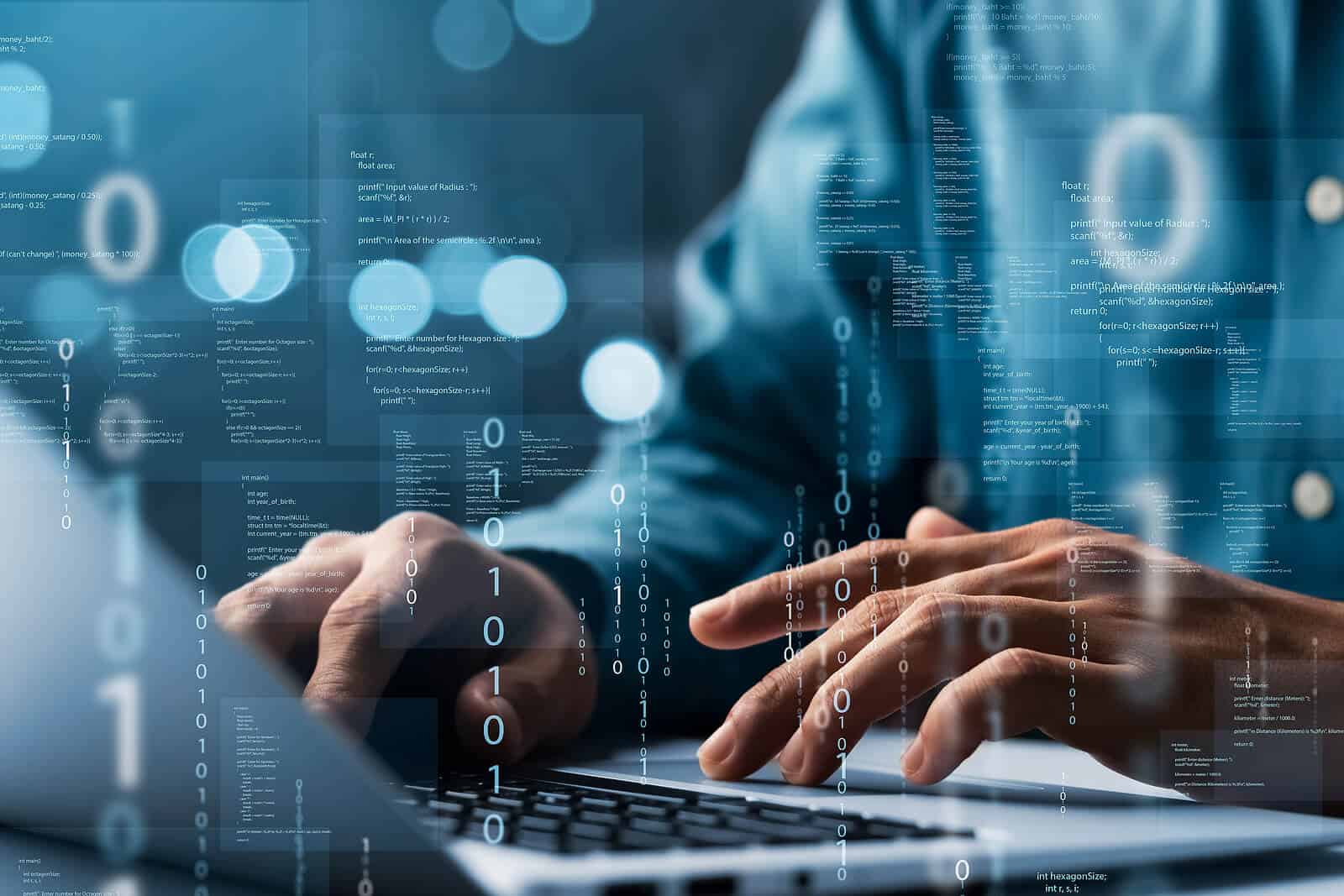 Hands working on a laptop with code and data overlays